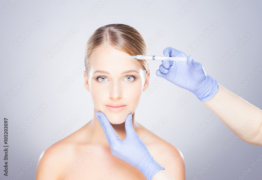 Doctor injecting botox into a woman's face Doctor injecting botox into a woman's face