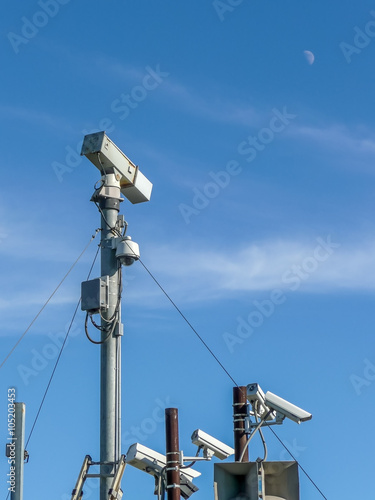Multiple surveillance cameras with blue sky and moon