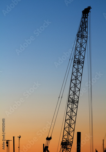 Silhouette of a construction crane at sunset.