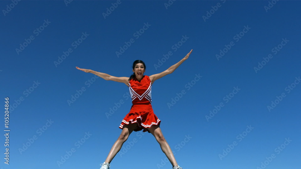 Cheerleader flies into air and does splits, slow motion Cheerleader flies into air and does splits, slow motion