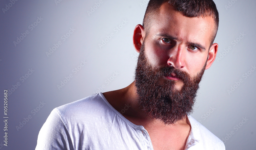 Obraz premium Portrait of handsome bearded man standing, isolated on grey background