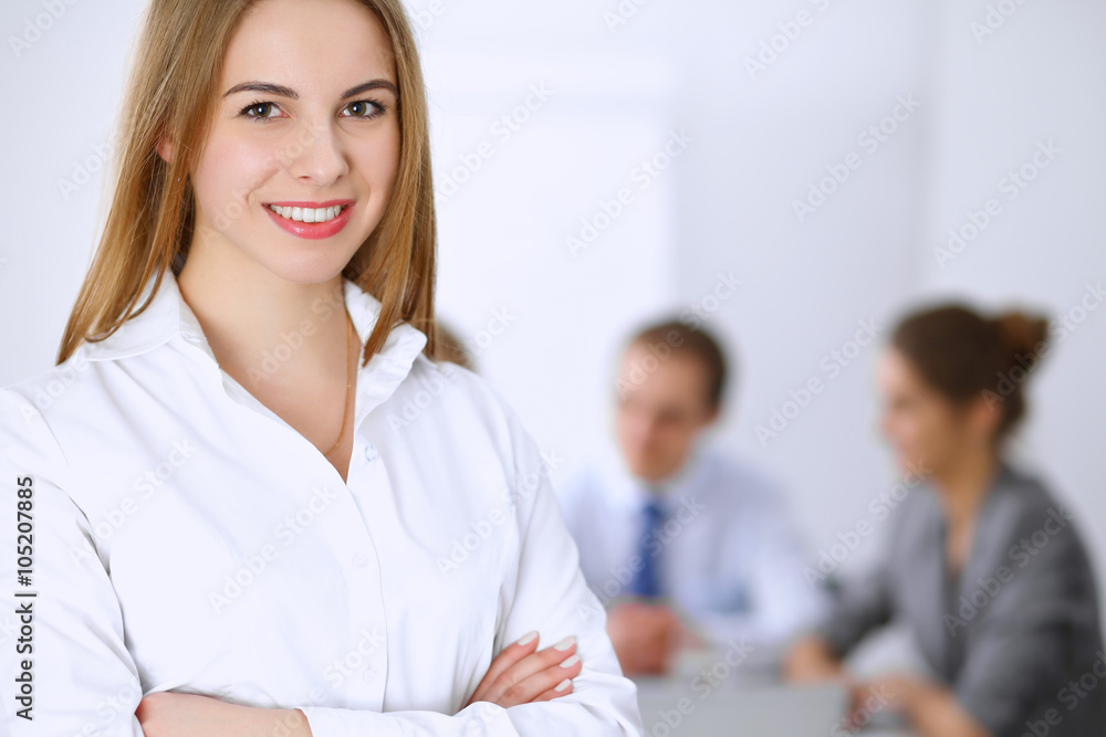 Beautiful business woman on the background of business people during meeting Beautiful business woman on the background of business people during meeting