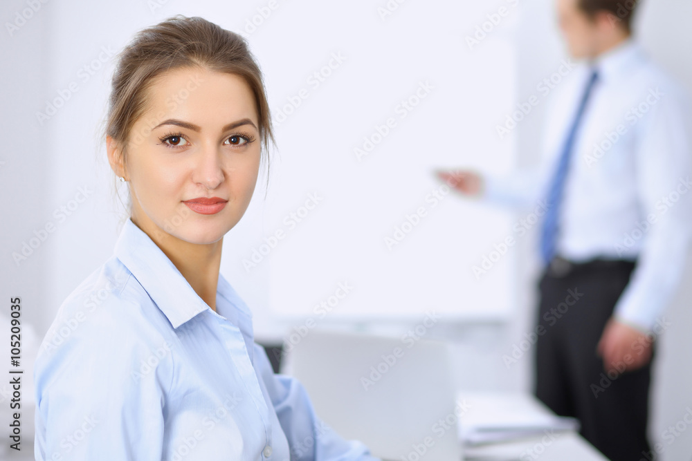 Obraz premium Beautiful business woman on the background of business people during meeting