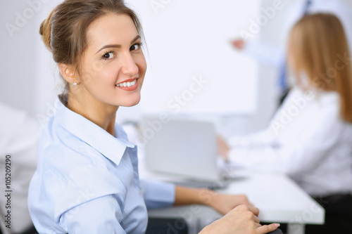 Beautiful business woman on the background of business people during meeting