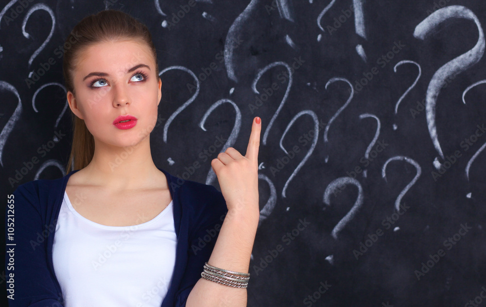 Young girl with question mark on a gray background Young girl with question mark on a gray background