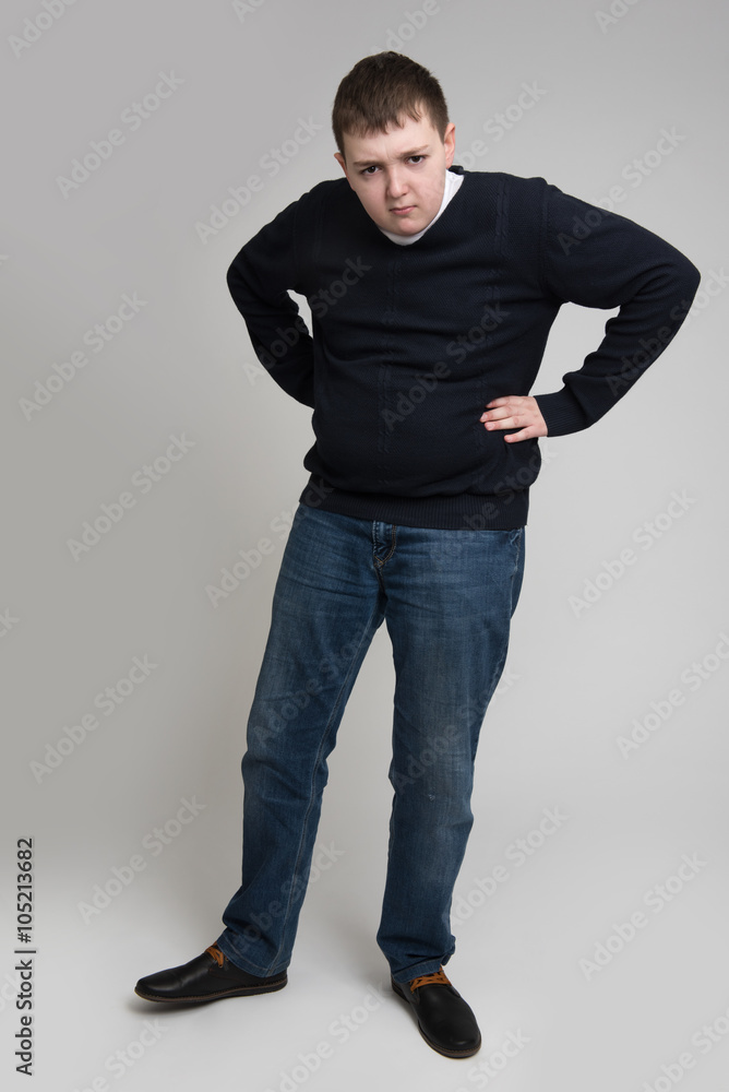 teen boy standing with his hands on hips teen boy standing with his hands on hips