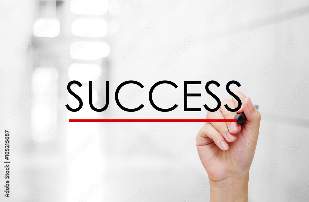 Hand holding pen and success word on blur background Hand holding pen and success word on blur background