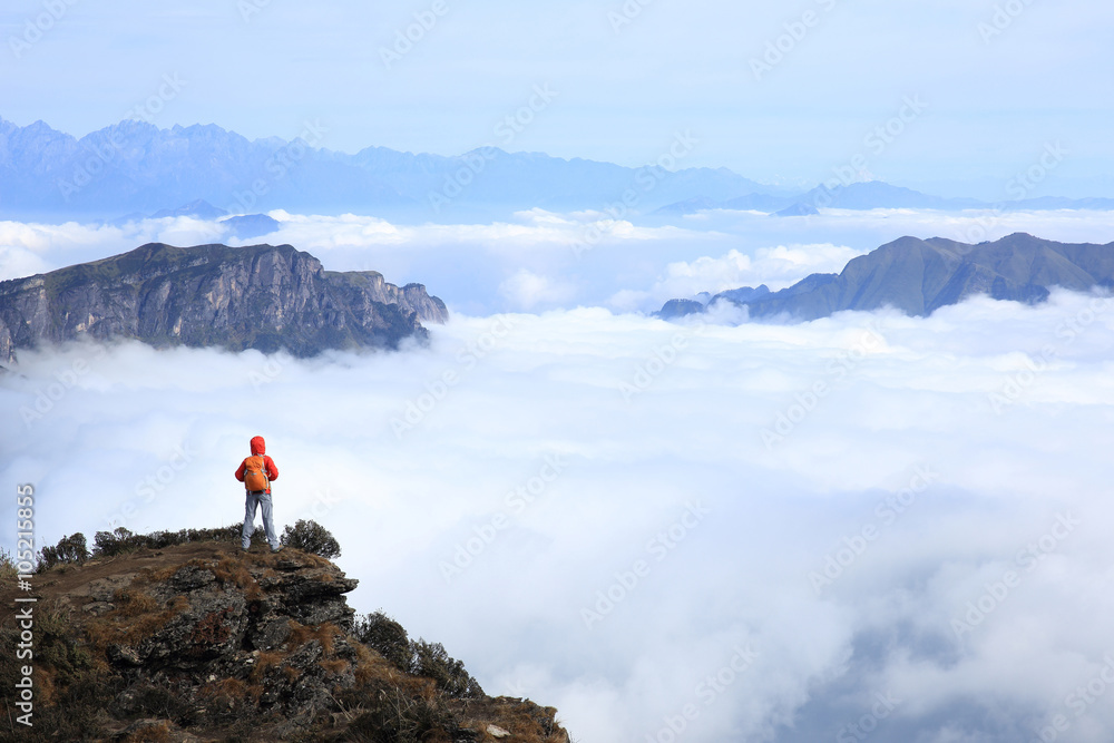 young woman backpacker hiking at mountain peak