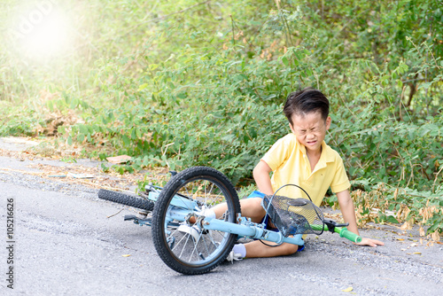 Boy fall from the bicycle during ride on the road © TinPong