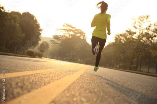 young fitness woman runner athlete running on sunrise road