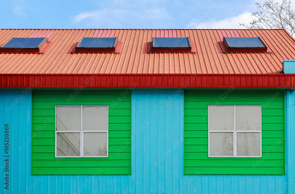 Painted colorful wall of residential building against blue sky. Painted colorful wall of residential building against blue sky.
