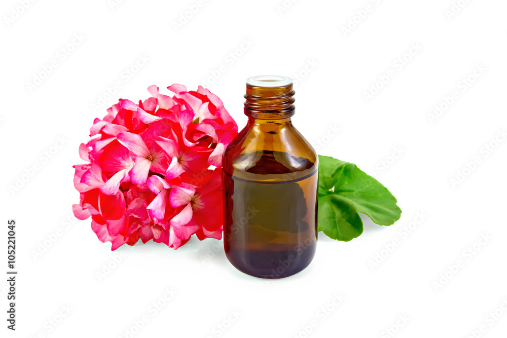 Oil with pink geraniums in dark bottle Oil with pink geraniums in dark bottle
