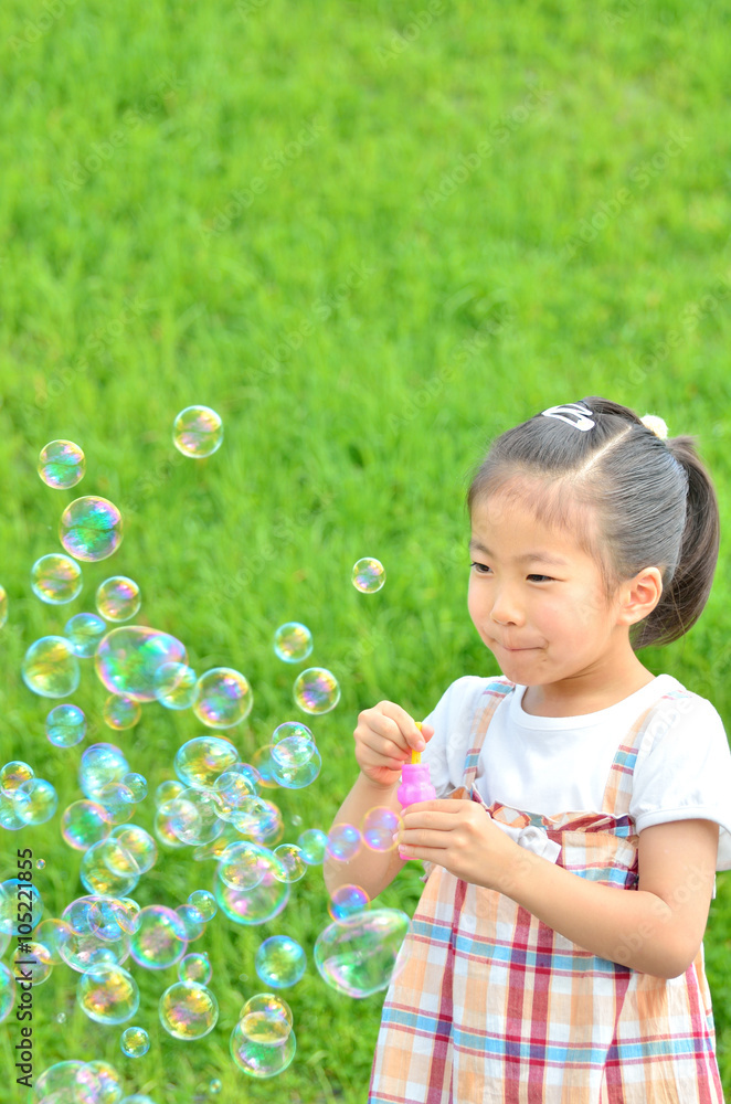 芝生広場でシャボン玉遊びをする女の子 芝生広場でシャボン玉遊びをする女の子
