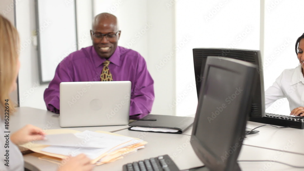 Coworkers working on laptops and computers Coworkers working on laptops and computers