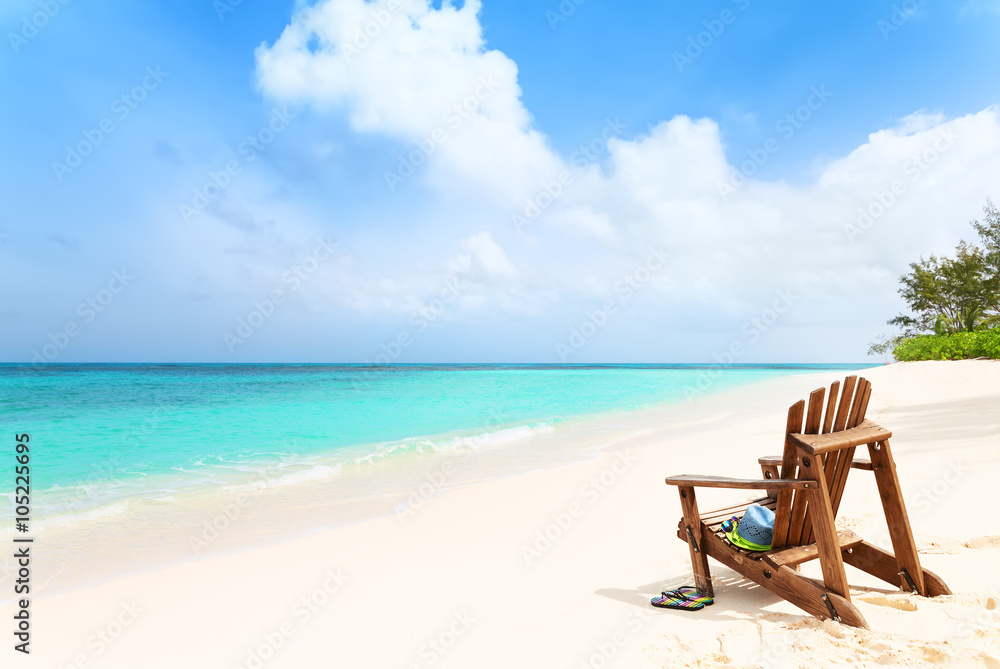 Lonely beach chair with hat and slippers at tropical beach, summ