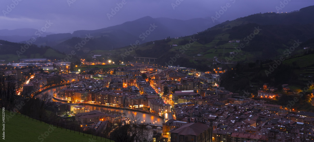 City lights at night with mountains background, Tolosa, Basque Country.