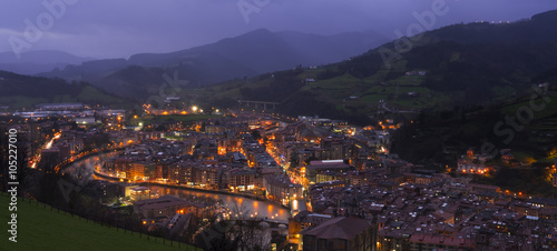 City lights at night with mountains background, Tolosa, Basque Country. © poliki