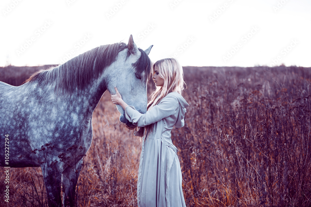 Fototapeta piękna blondie z koniem w polu, efekt tonizujący