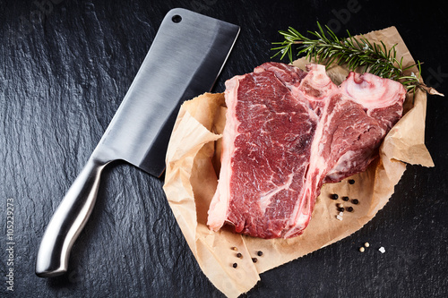 Meat cleaver beside raw steak photo