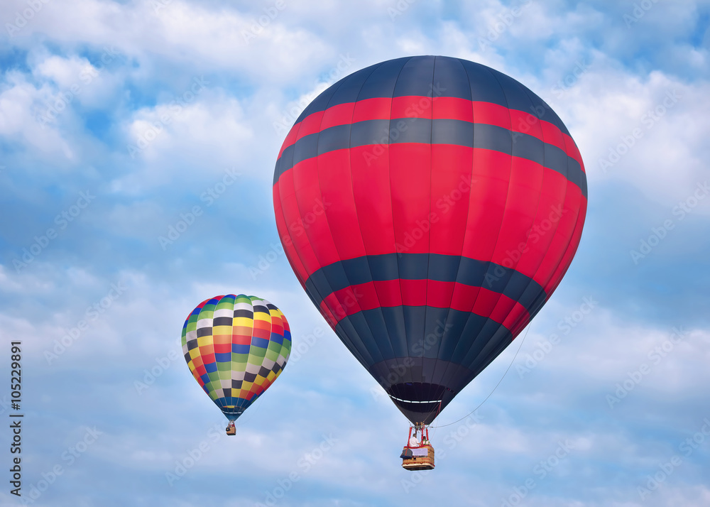 Fototapeta premium Pair Of Colorful Hot Air Balloon in Cloudy Blue Sky