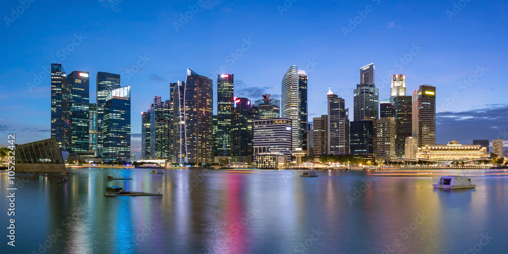 Colorful Singapore business district skyline after sun set at Marina Bay. Panoramic image.