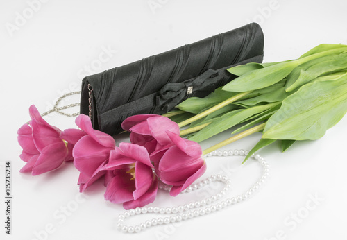 Fototapeta Naklejka Na Ścianę i Meble -  bouquet of red tulips, handbag and bead lying on a white background