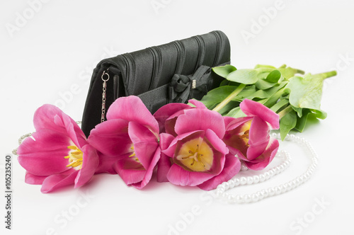 Fototapeta Naklejka Na Ścianę i Meble -  bouquet of red tulips, handbag and bead lying on a white background