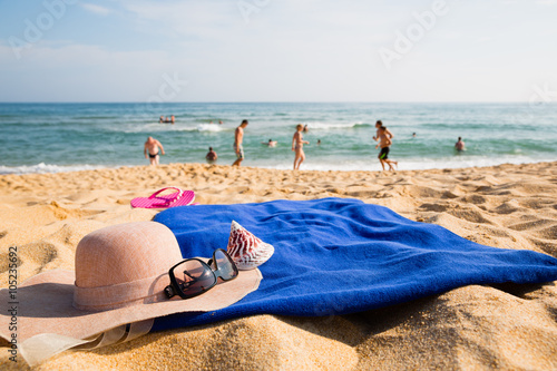 Hat, towel, sunglasses and slippers on a tropical beach