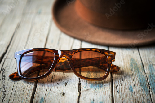 Sunhat and sunglasses on wooden table