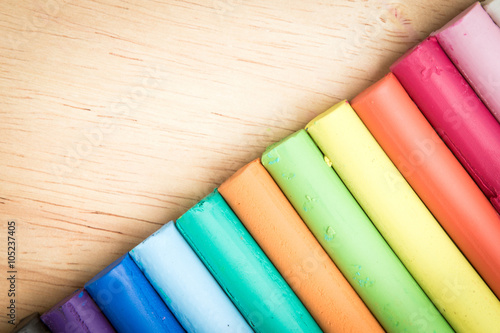 multicolor plasticine bar arrange on a wood background