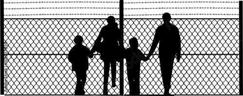 family in front of the security fence 