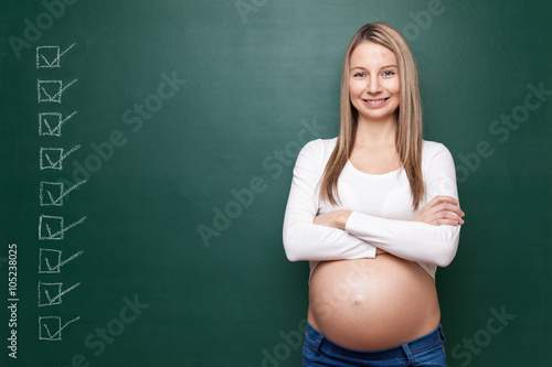 Pregnant woman and a blackboard with copyspace photo
