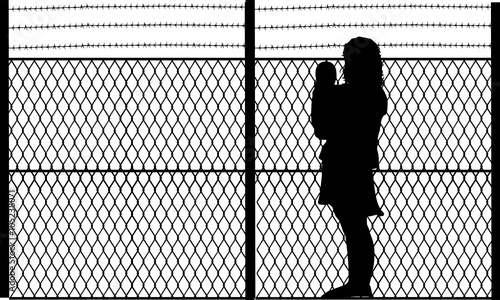 a mother in front of a security fence 