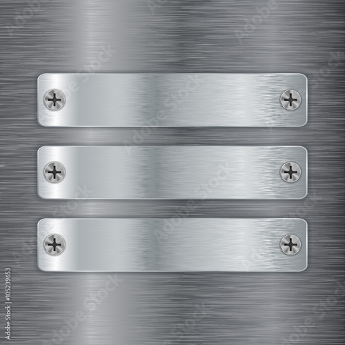 Metal plate with screw head on brushed steel background.