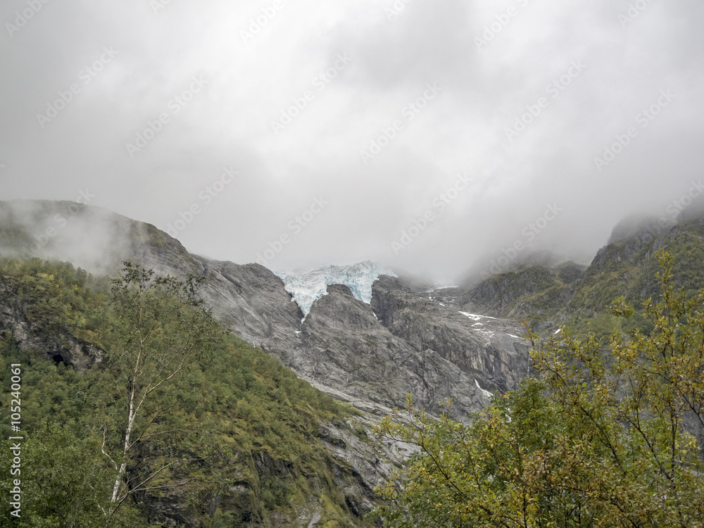 Ewiges Eis im Grünen/eine Gletscherzunge im Herbst bei starker Wolkenbildung