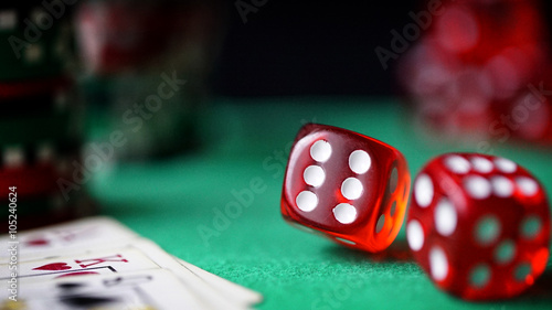 Red dice, casino chips, cards on green felt