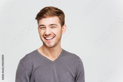 Cheerful attrative young man in grey pullover