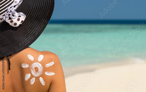 Woman with sun-shaped sun cream photo