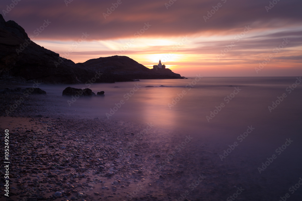 Sunrise at Bracelet Bay, featuring Mumbles Lighthouse in Swansea, South Wales