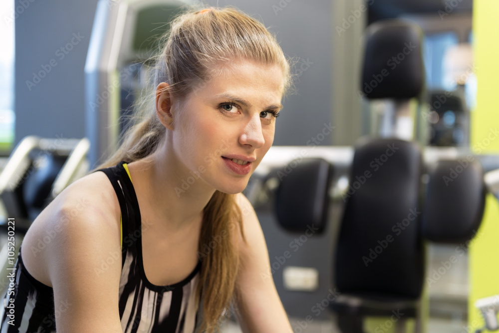 Portrait of young woman in a gym during brake in exercise