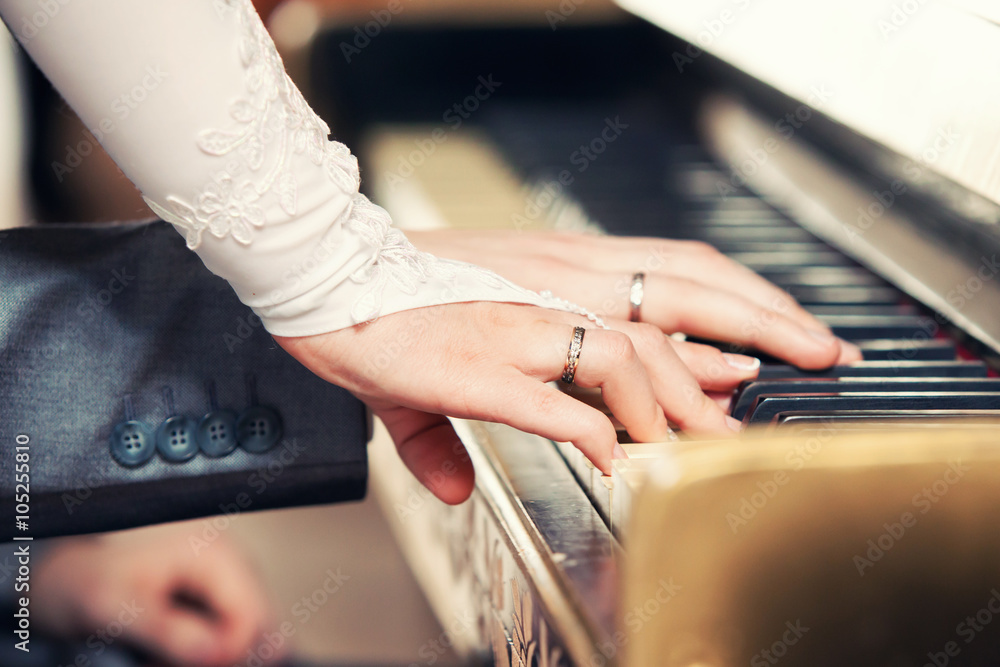 newlyweds play on grand piano keys