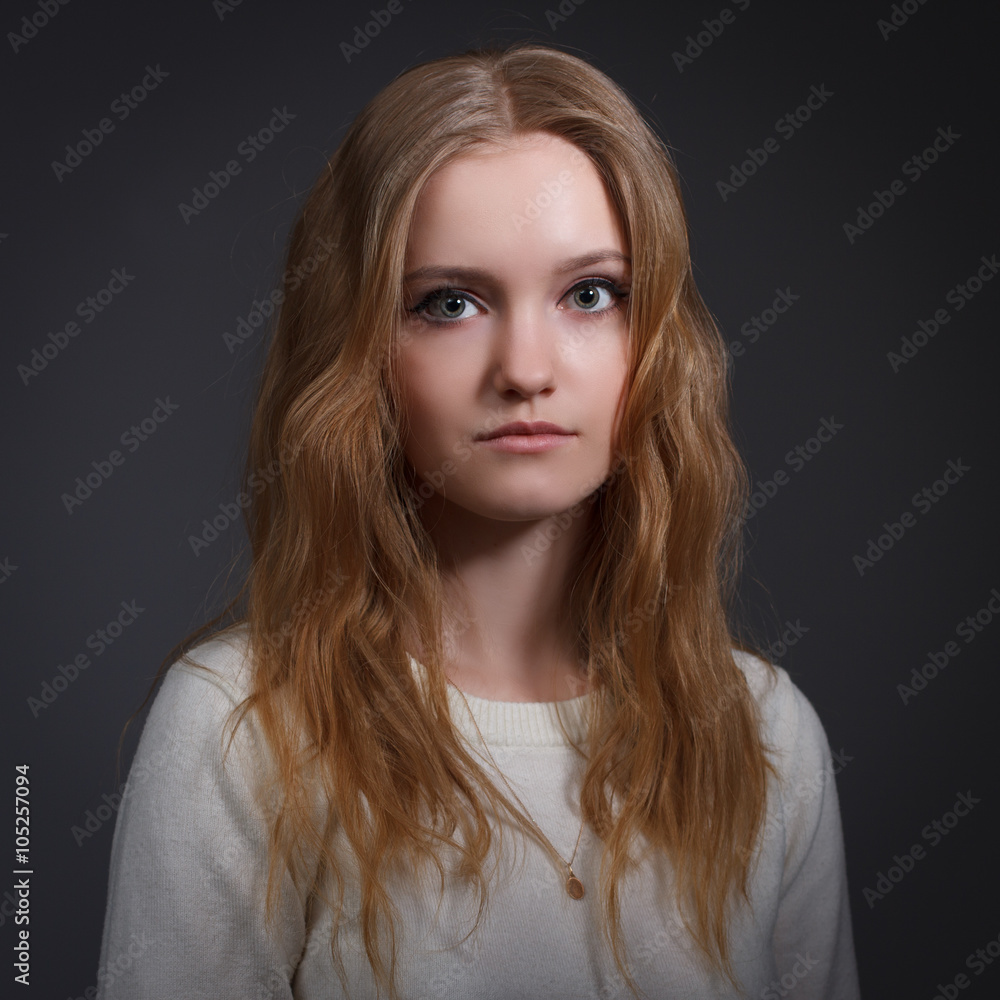 Portrait of a beautiful young woman on a dark background . Portrait of a beautiful young woman on a dark background .