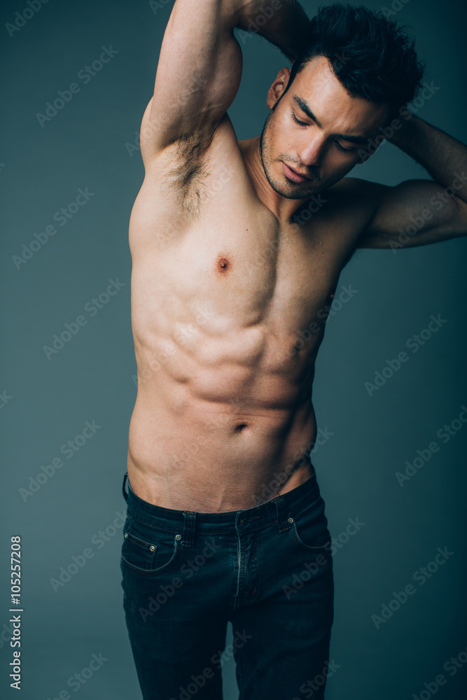 Fototapeta premium Muscular young sexy guy posing in studio in jeans and naked torso