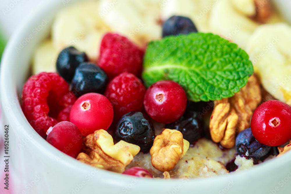 Healthy Breakfast. Oatmeal with fresh berries, bananas nuts and honey
Healthy Breakfast. Oatmeal with fresh berries, bananas nuts and honey