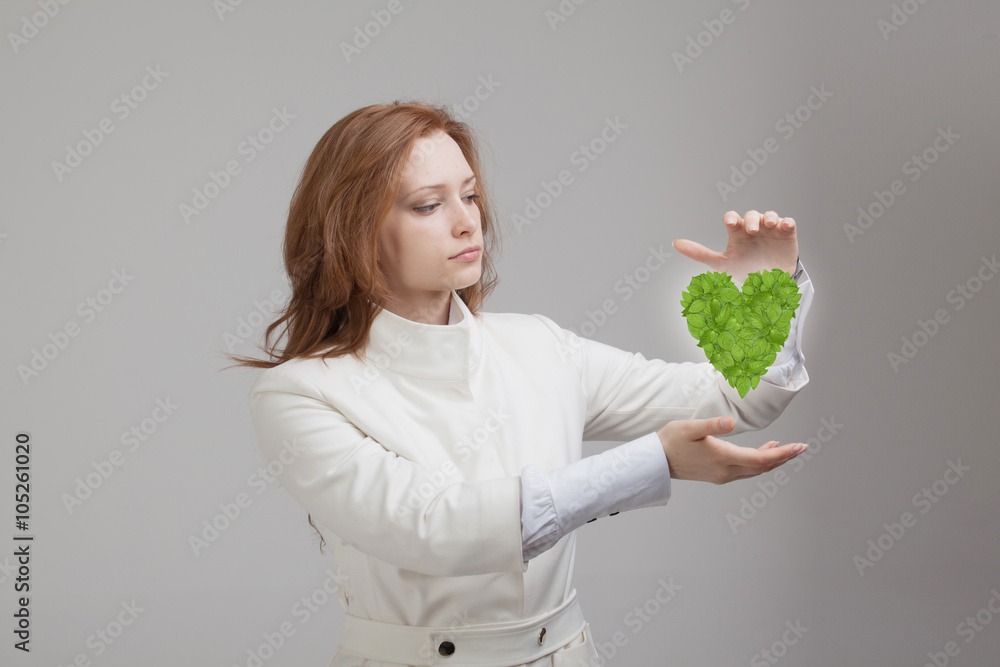 Woman holding green plant heart in her hands Woman holding green plant heart in her hands