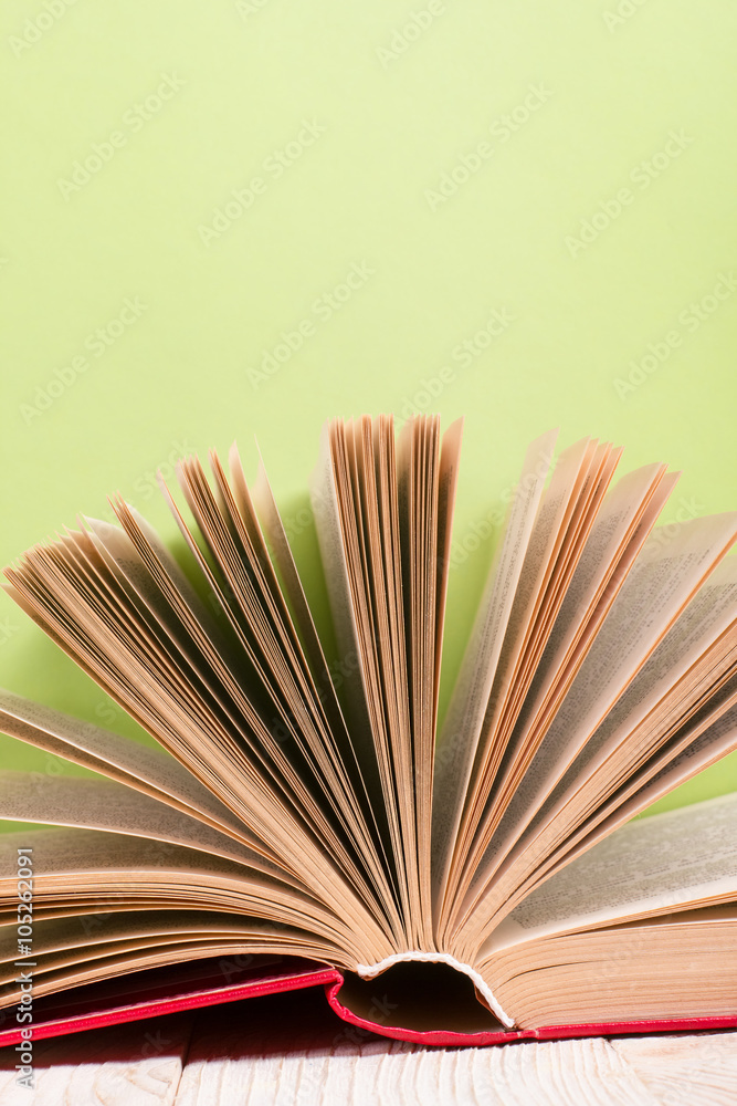Fototapeta premium Open book on green wooden bavkground. Education background.