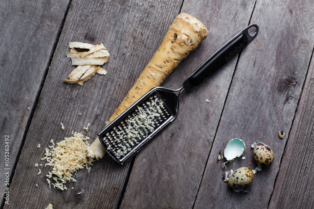 Grated horseradish root, grater and quail egg and broken shell on gray  wooden background. Stock Photo | Adobe Stock