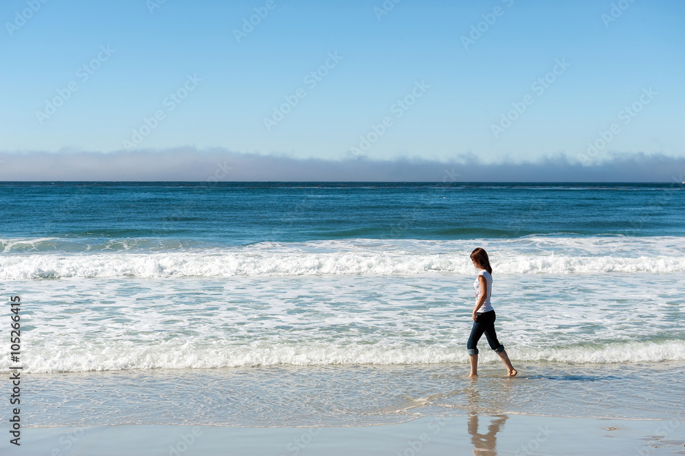 young woman walking on beach