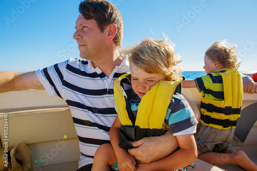 Father and two kid boys enjoying sailing boat trip