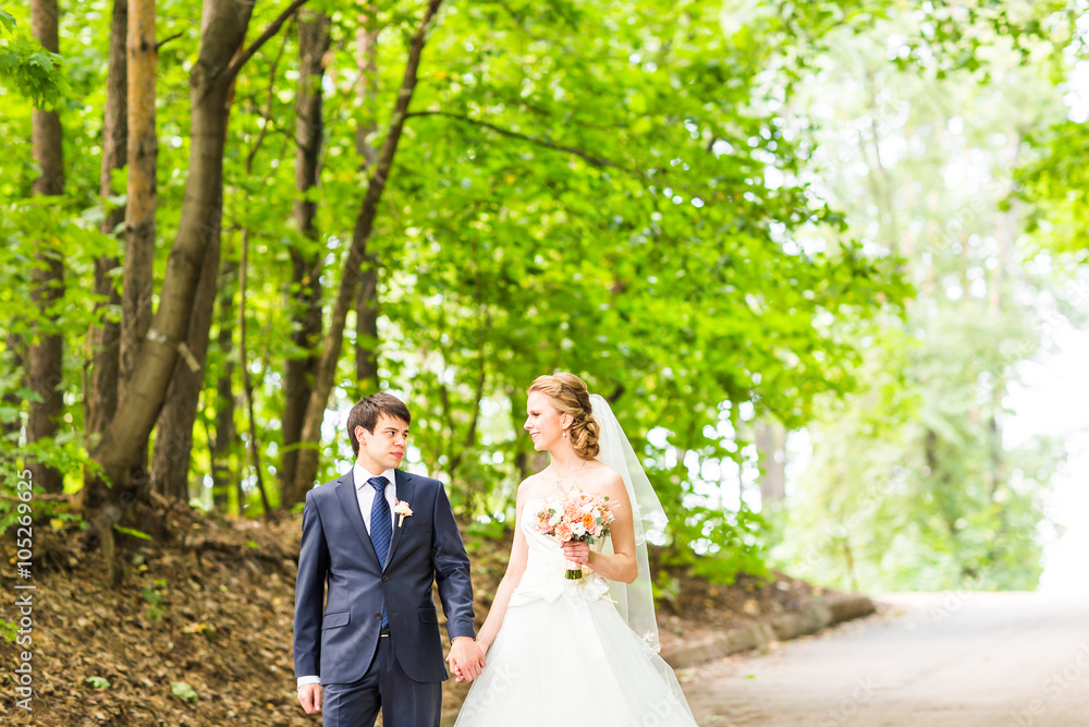 happy bride and groom at a park on their wedding day happy bride and groom at a park on their wedding day